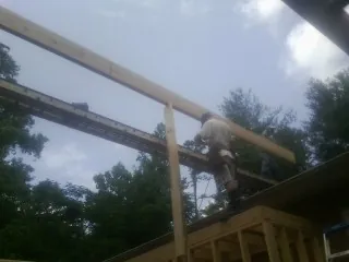 Carpenter setting a ridge beam over a new addition frame — Ice Dam Removal by Roofing Brothers in Talent
