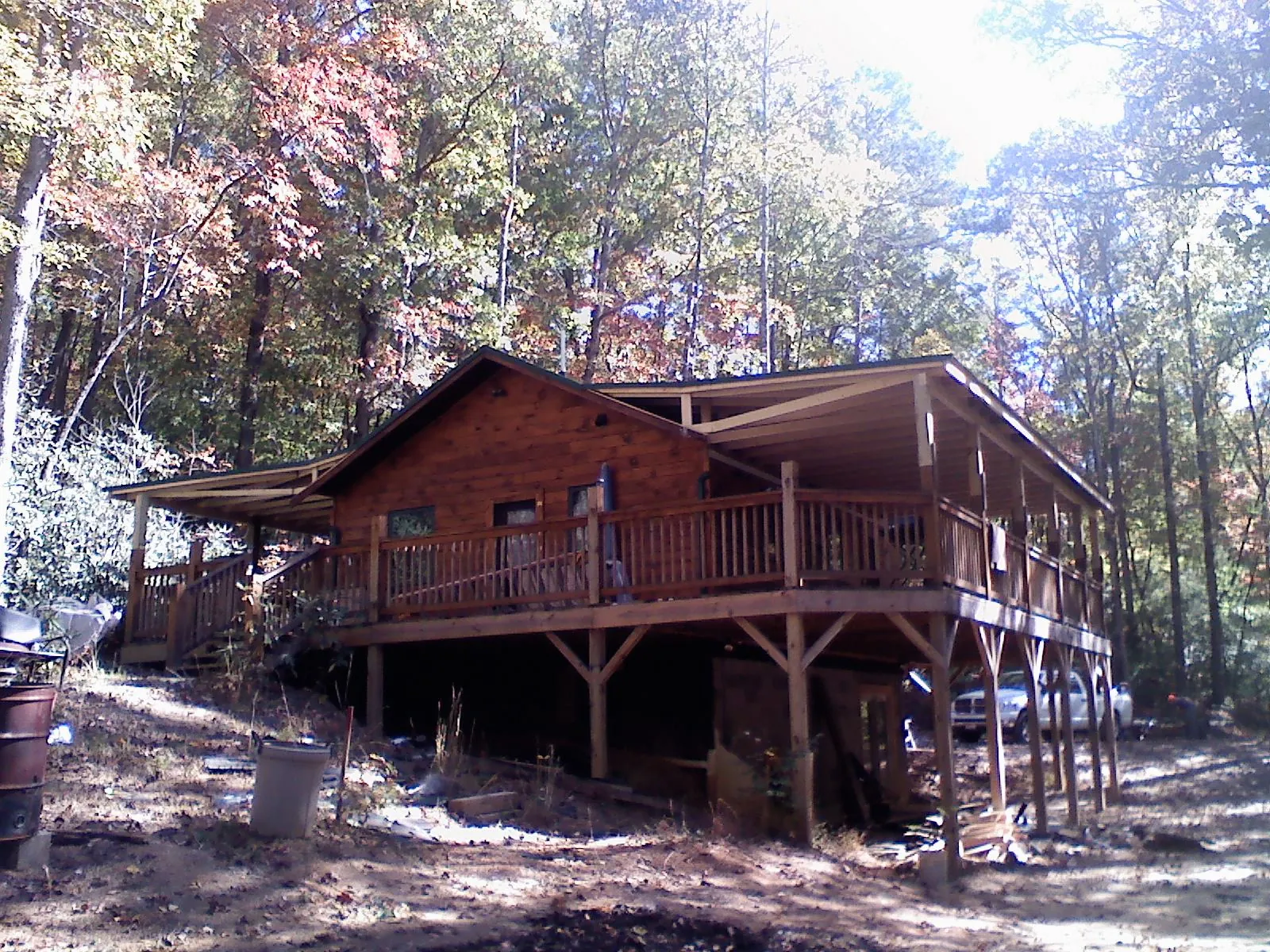 Log cabin with a wraparound porch and metal roof in the fall in Talent