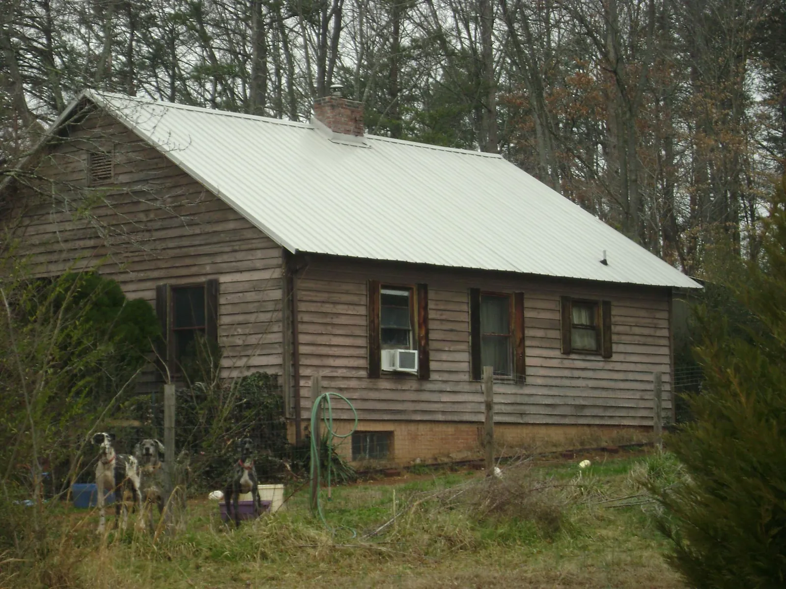 White metal roof on an old wood sided farmhouse, from a Metal Roof Installation job in Talent